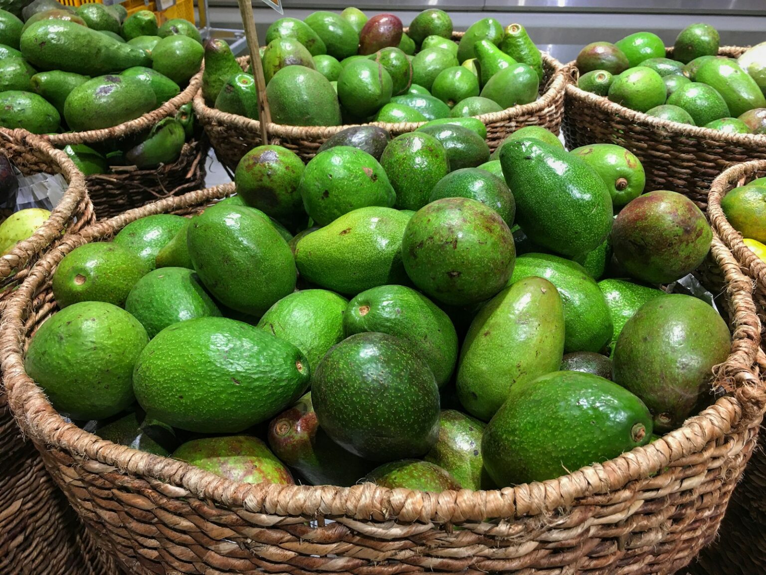 green fruits on brown woven basket