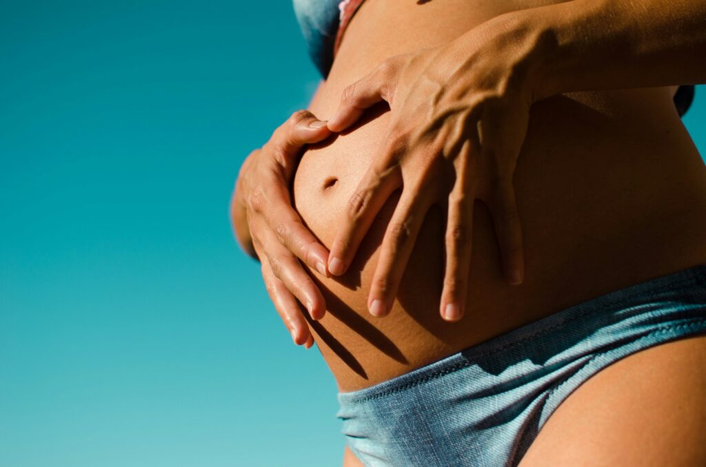 closeup photography of pregnant woman wearing blue panty