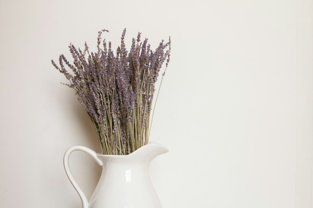 white ceramic vase with purple flowers