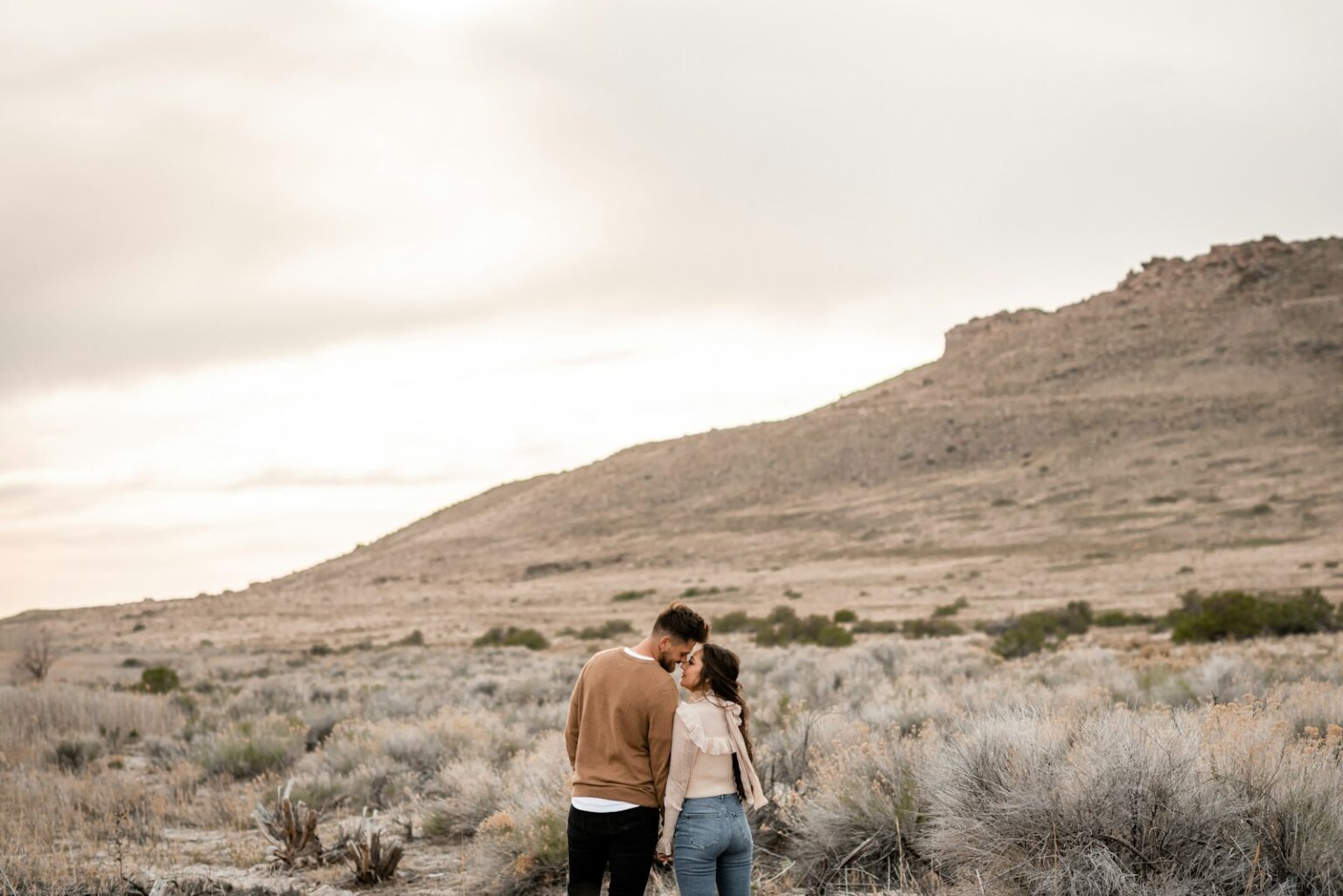 A man and a woman are standing in the desert