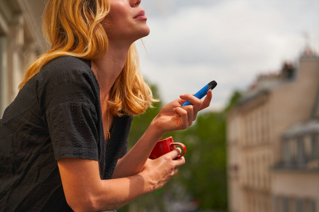 a woman holding a cup and a cell phone