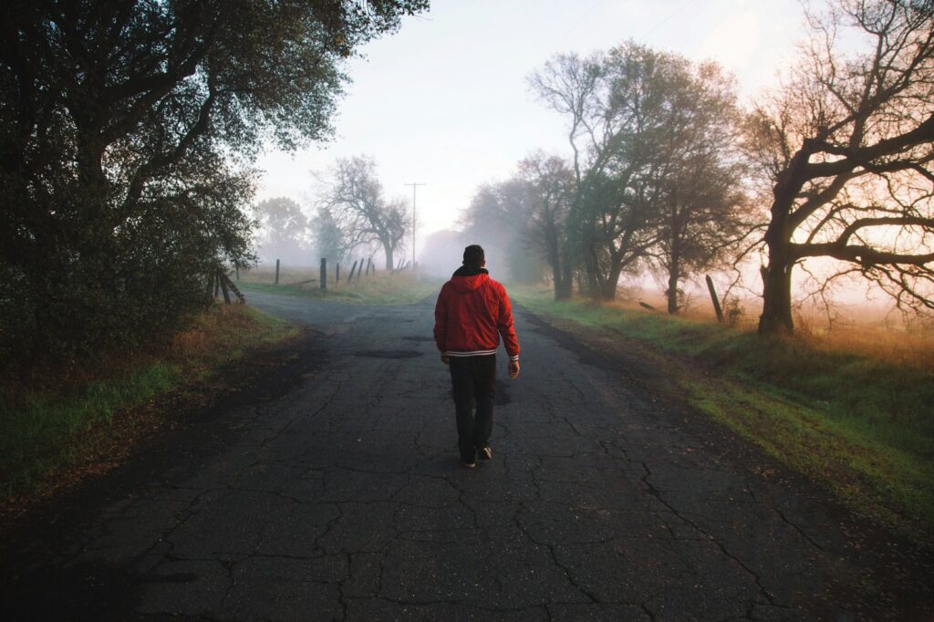 man walking on road at daytime