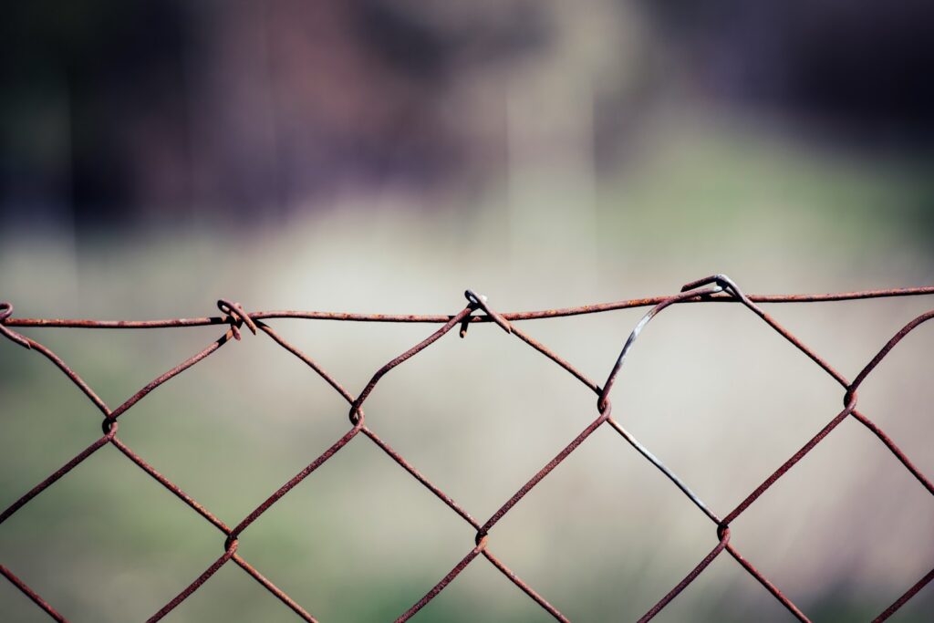 gray metal fence with barbwire