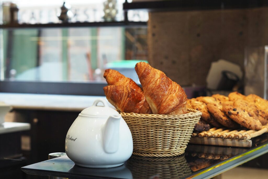 white ceramic teapot beside brown wicker basket on table