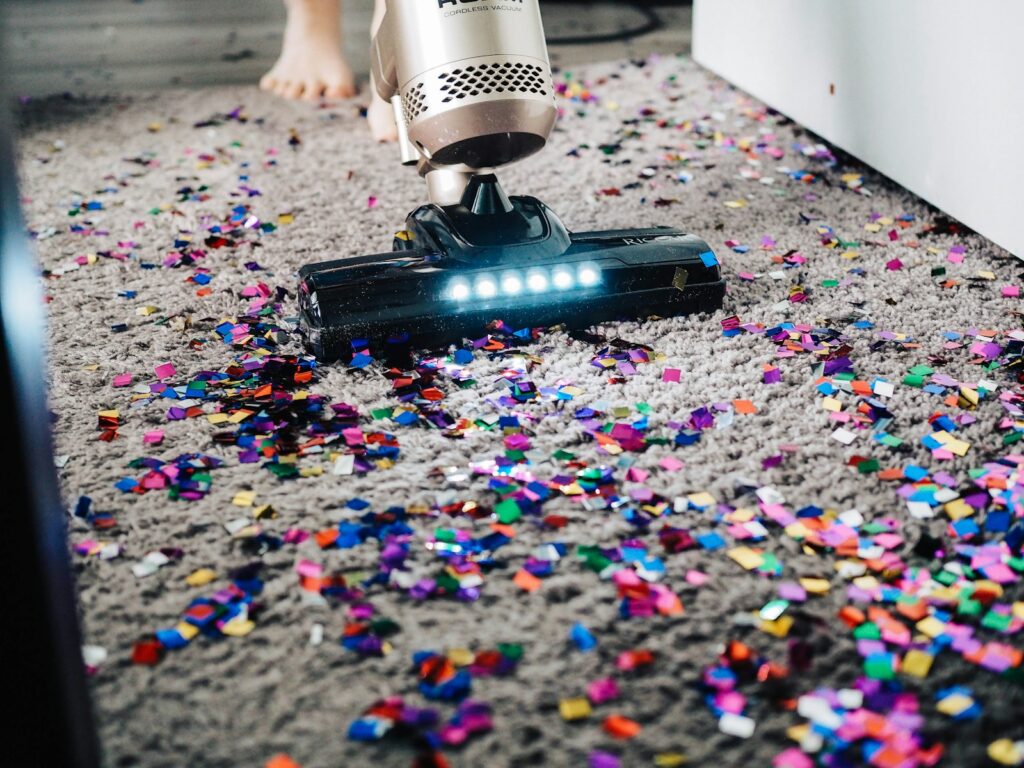 a person using a vacuum to clean a carpet