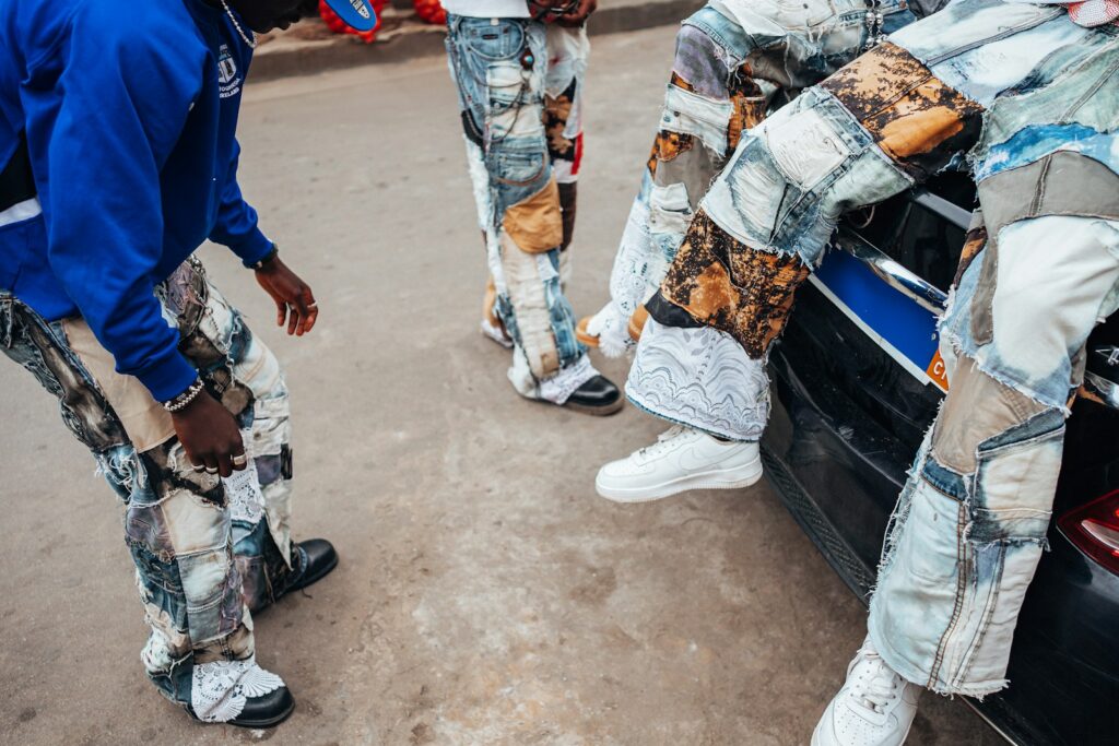 A group of young men standing next to a car