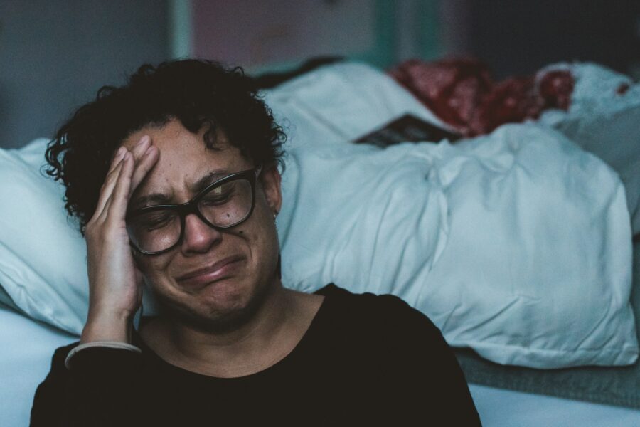 person crying beside bed