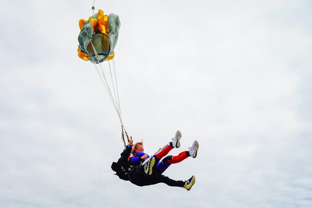 a man flying through the air while holding onto a parachute