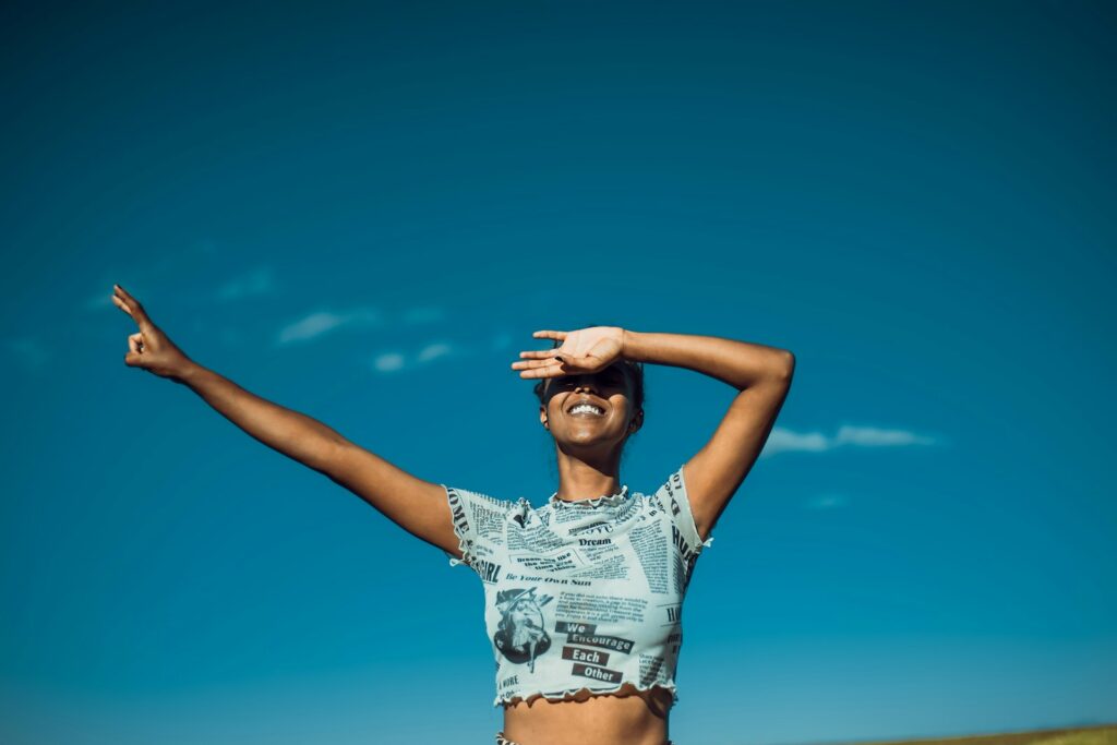 a woman standing in a field with her arms outstretched