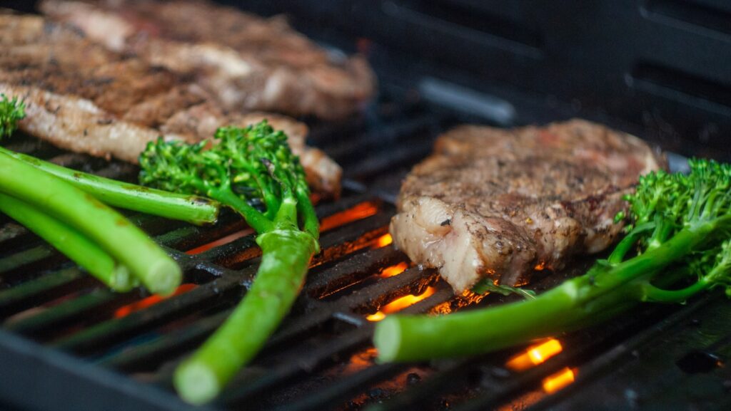 grilled meat with green vegetable on black grill