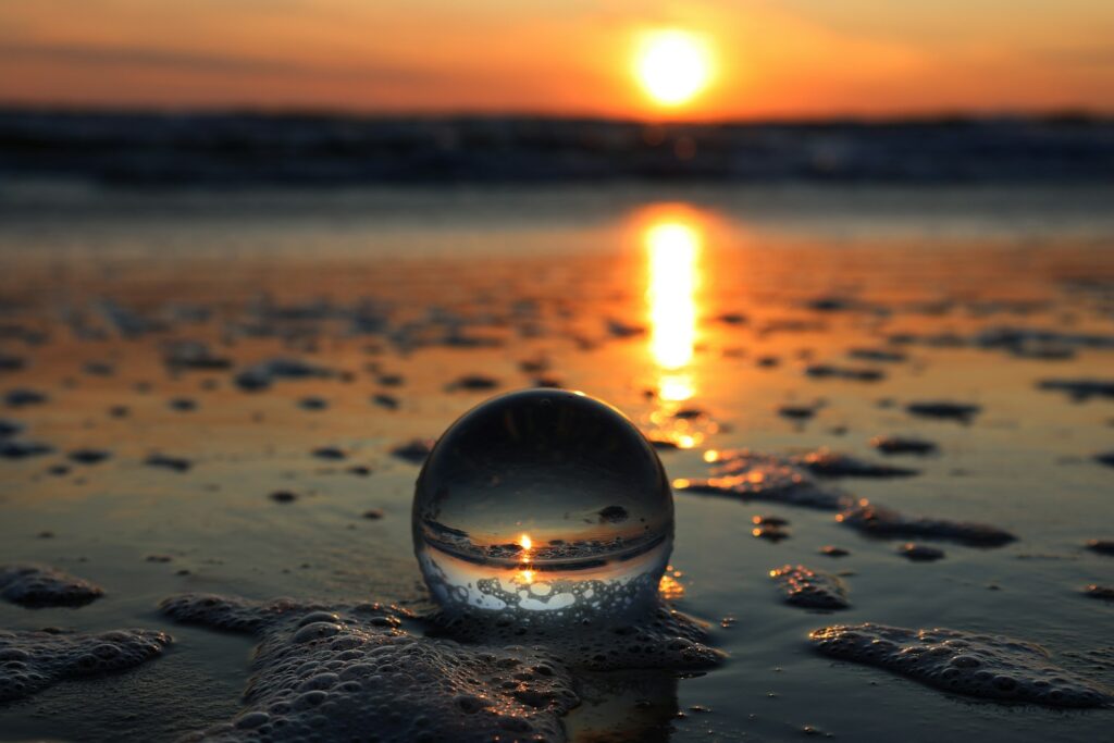 A crystal ball sitting on top of a sandy beach