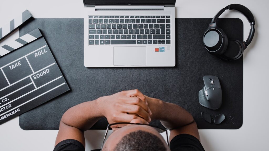 a person sitting at a desk with a laptop and headphones