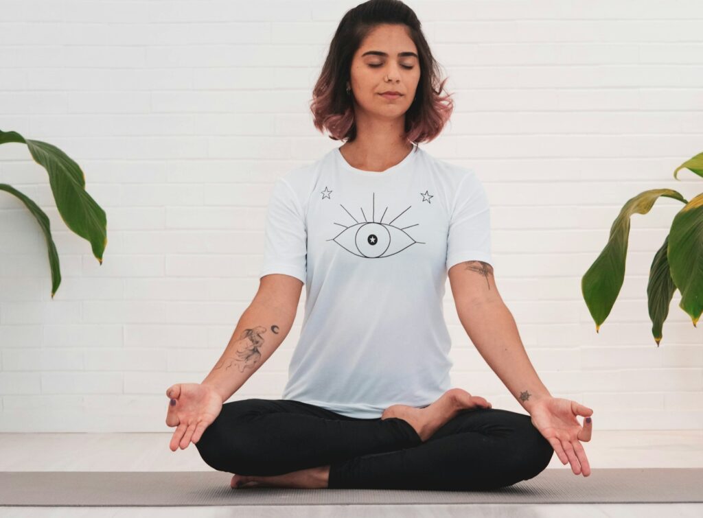 woman in white crew neck t-shirt and black pants sitting on white table