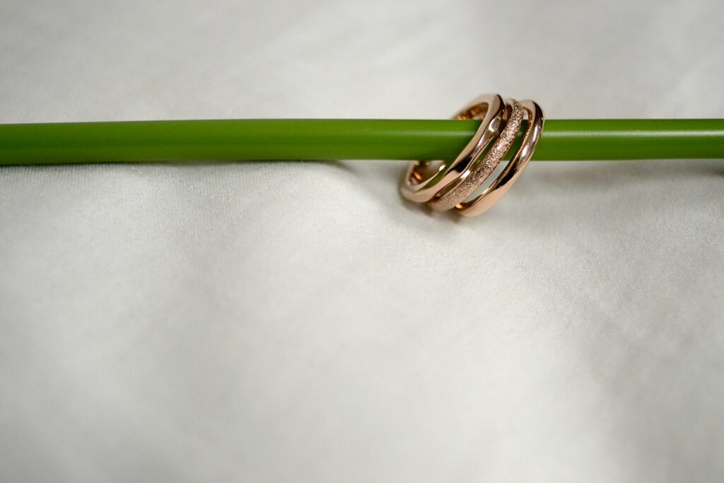 gold and silver ring on white textile