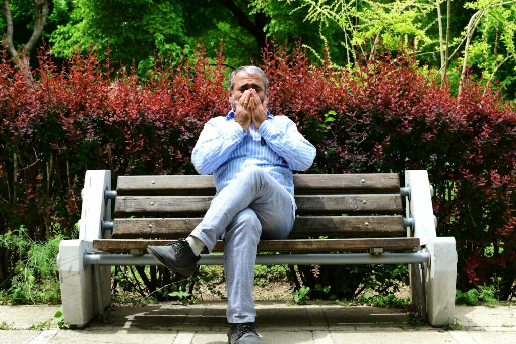 A man sitting on a bench in a park